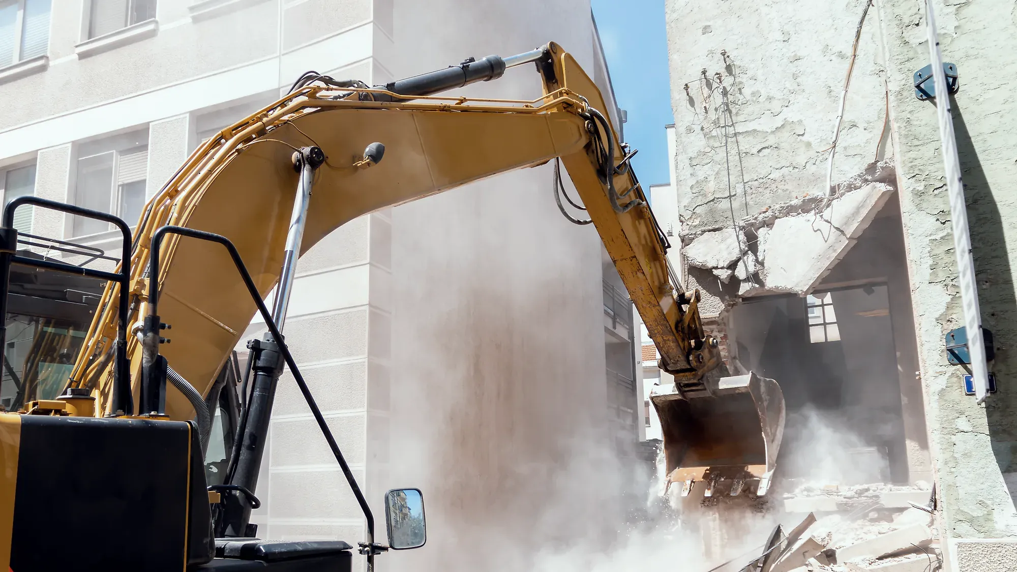 Abbrucharbeiten an einem Wohngebäude, Bagger mit Sortiergreifer am Mauerwerk.