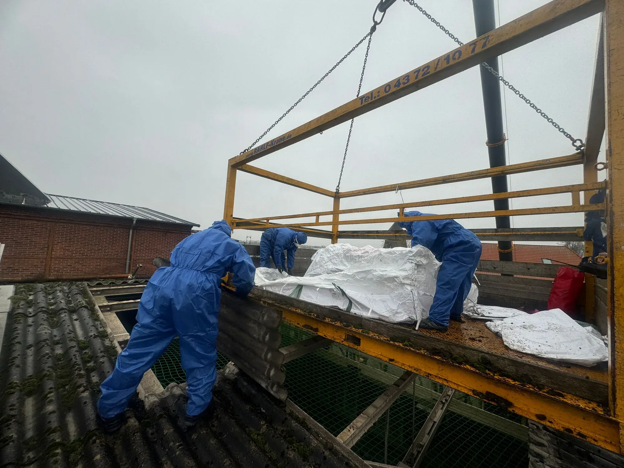 Abgeschotteter Arbeitsbereich einer Asbestsanierung mit Folienschleuse und Warnkennzeichnung.