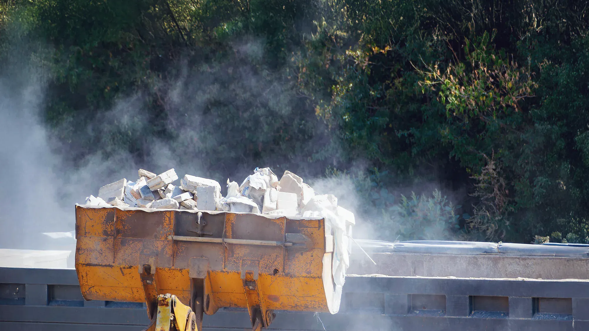 Getrennt gelagerte Bauabfallfraktionen auf einer Baustelle, daneben ein Absetzcontainer.